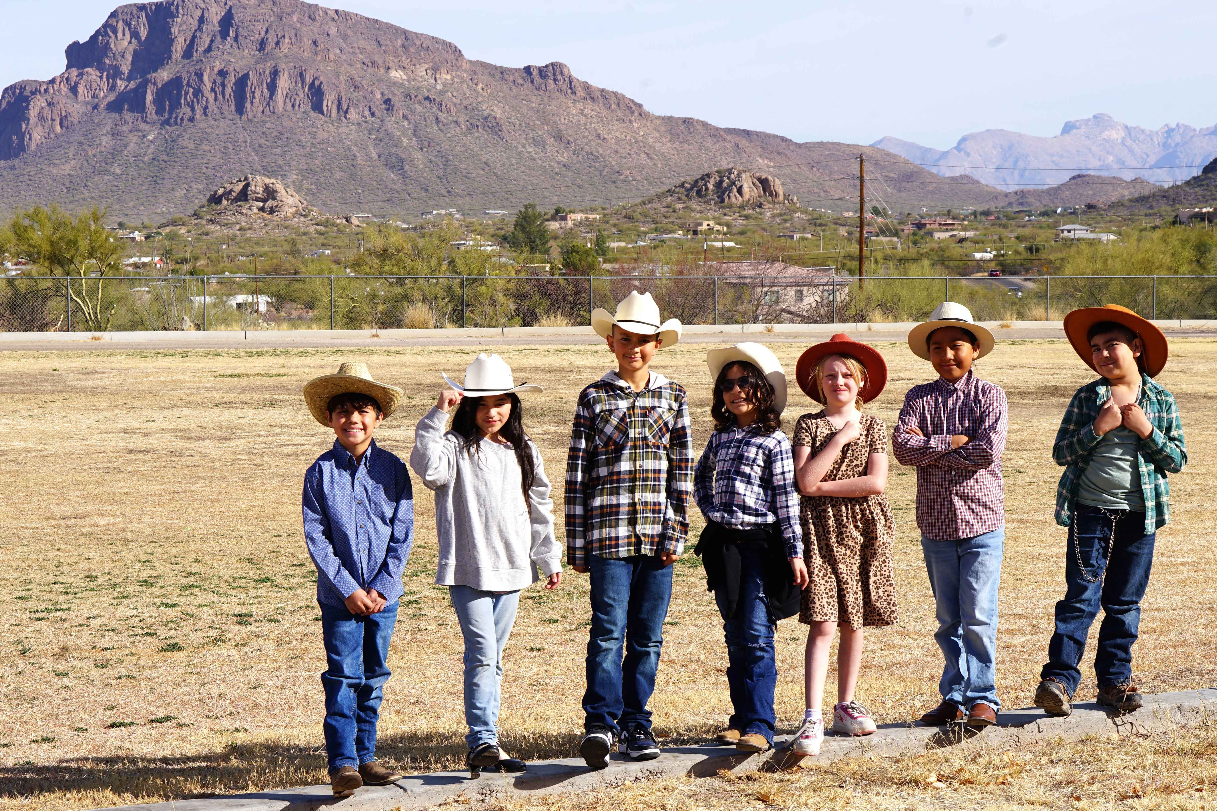 A group of students show off their rodeo gear outside