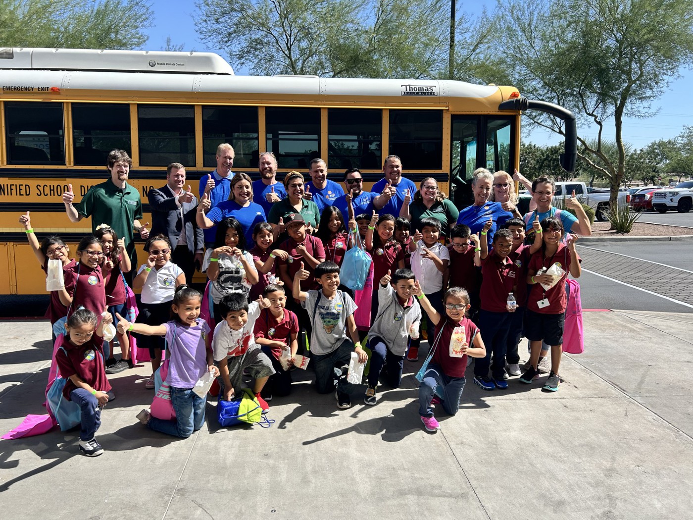 Johnson students stand outside in front of a school bus