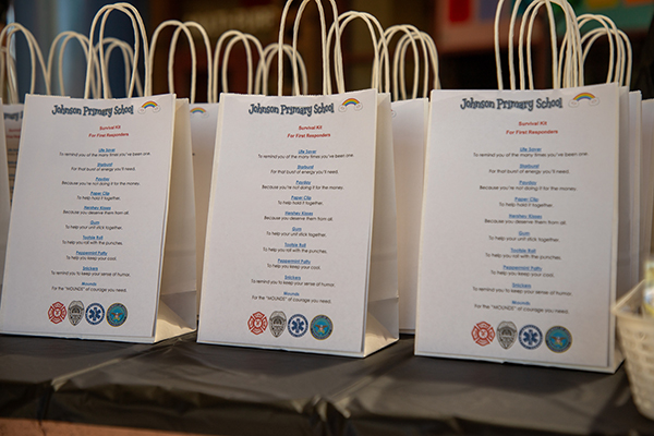 A table filled with paper goodie bags for the first responders