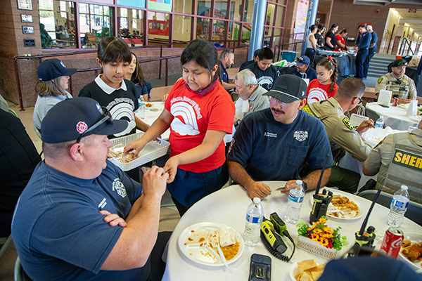 Two girls pass out cookies to the first responders