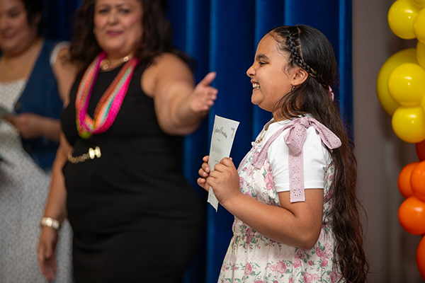 A girl smiles as her principal points to her during the promotion ceremony