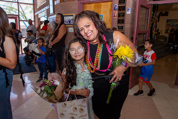 A young girl takes a photo with her principal