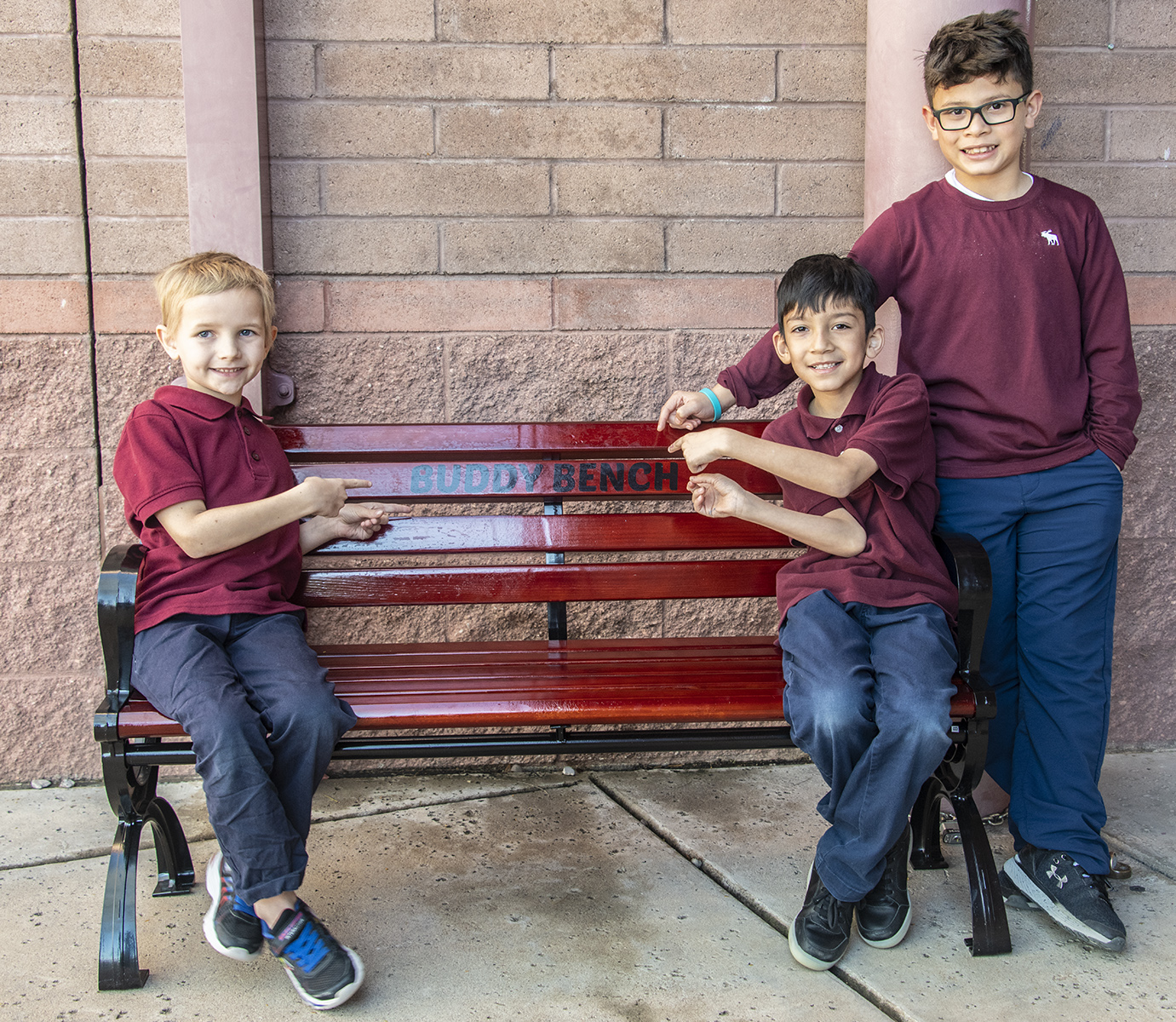 students sitting happily on the buddy bench